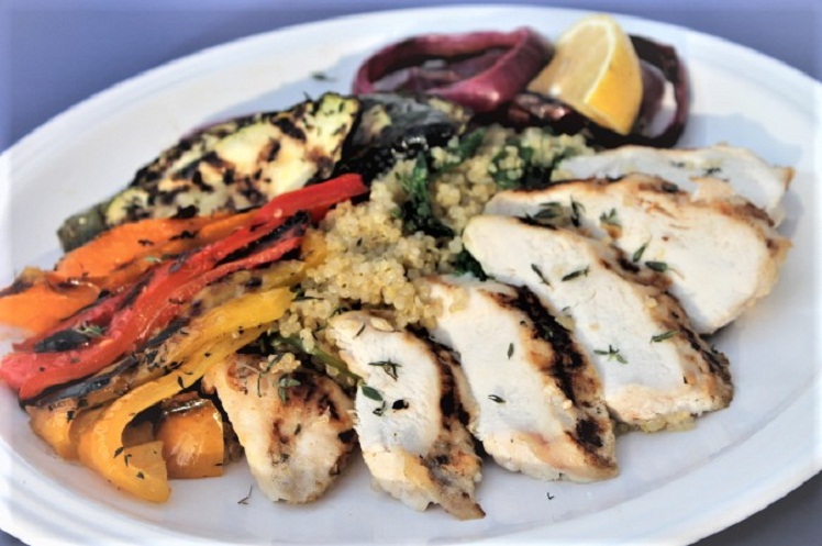 Grilled lemon thyme chicken with seasonal vegetables over spinach quinoa