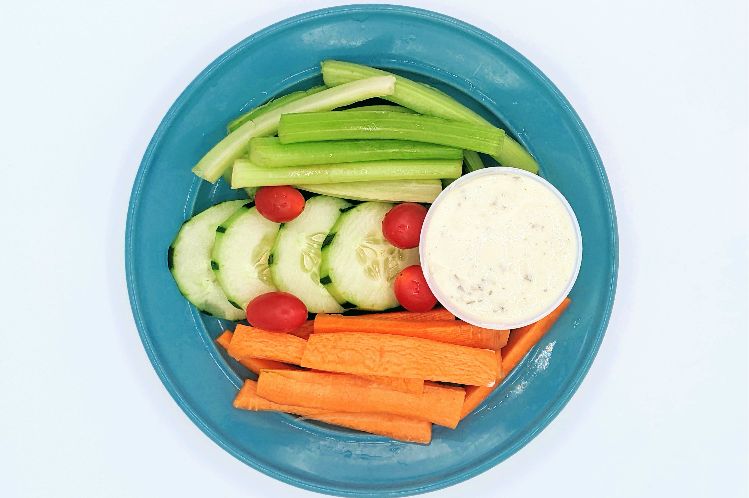 Mini veggie tray side dish with carrots, celery, cucumbers, cherry tomatoes and ranch dip from Meal Village