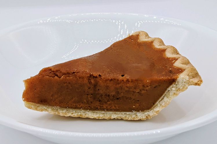 A slice of perfectly spiced pumpkin pie in a flaky crust.