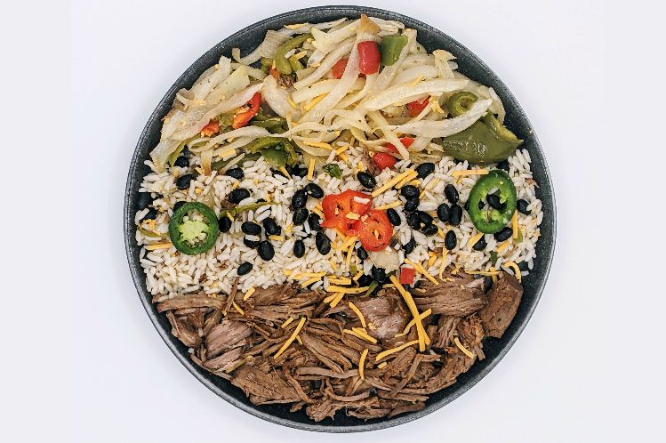 Chipotle barbacoa beef bowl served over black beans and rice with flour tortillas