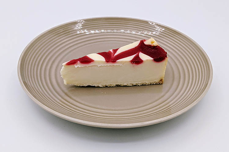 Creamy strawberry swirl cheesecake slice made with real strawberries.