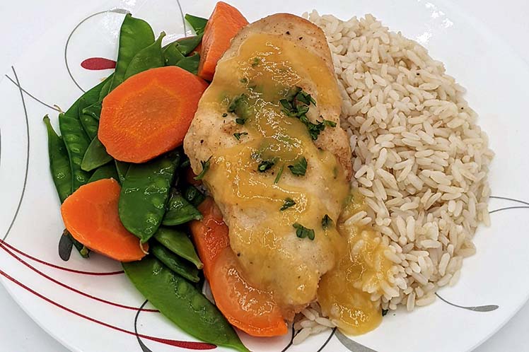 Sticky orange chicken and rice with sugar snap peas and carrots.